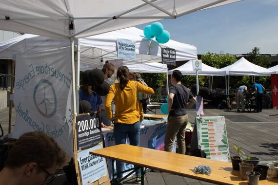The picture shows the sustainability market with tents, tables and people.